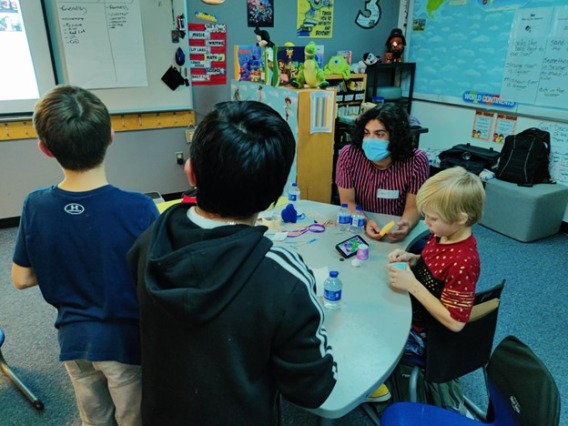 UA Intern helping kids with a crafts activity 