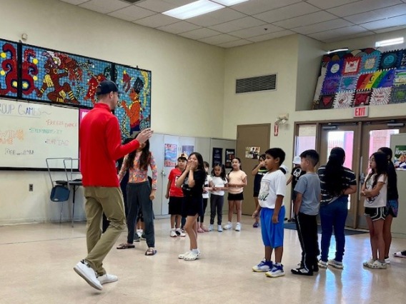 UA Student leading children in an activity 