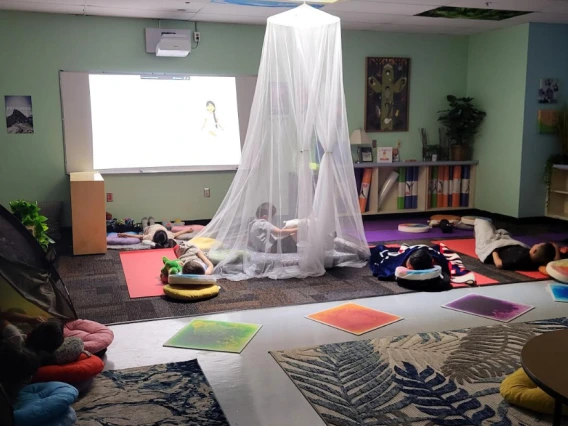 Little kids relaxing in the Zen Den with pillows and blankets.