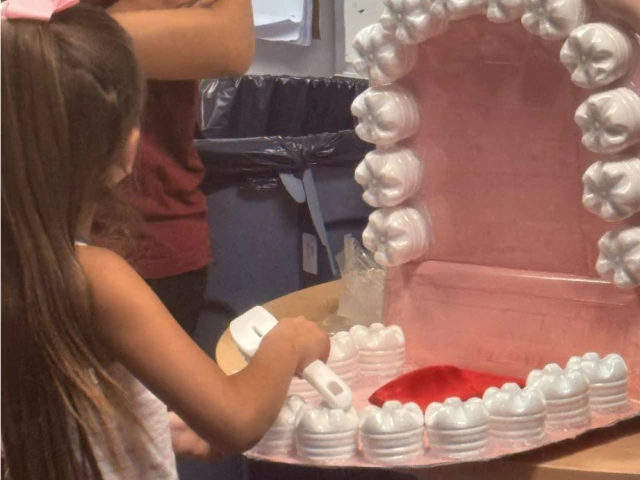 Girl flossing a teeth model