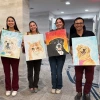 4 people holding up paintings of their pets. 